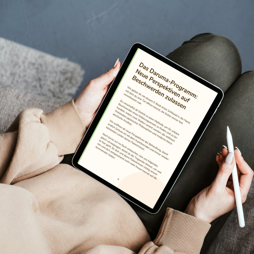 Eine Person hält ein Tablet, auf dem das E-Book 