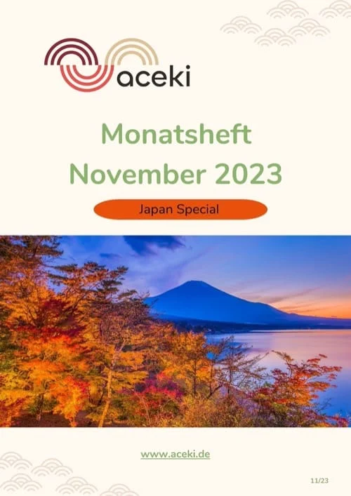 Mount Fuji bei Sonnenuntergang mit herbstlich gefärbten Bäumen in Rot und Orange im Vordergrund, spiegelt sich in einem ruhigen See unter blauem Himmel. Titelseite des aceki e.V. Monatshefts November 2023 mit dem Schwerpunkt Japan Special.