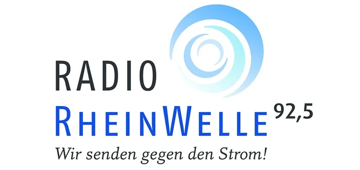 Logo von Radio Rheinwelle 92,5 mit dem Slogan "Wir senden gegen den Strom!" Das blaue und weiße Design zeigt konzentrische Kreise, die Radiowellen darstellen.