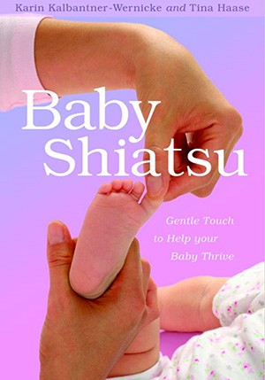 Ein Erwachsener führt sanfte Shiatsu-Massage an den Füßen eines Babys durch. Das Cover des Buches 