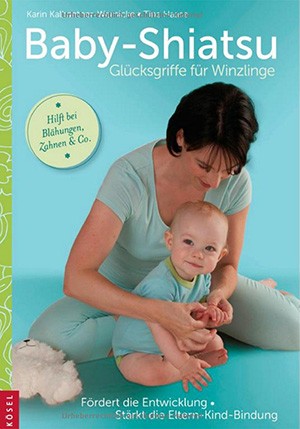 Eine Frau sitzt auf einem Gymnastikball und hält ein Kleinkind sanft in ihren Armen. Das Buch 