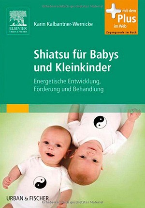 Zwei Babys in weißen Shirts mit Yin-Yang-Symbol liegen auf grünem Untergrund und lächeln in die Kamera. Das Buch 